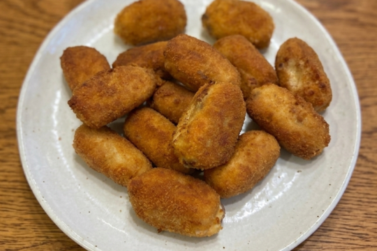 Plate of golden-fried croquetas de cocido madrileño, Spanish béchamel croquettes made from leftover stew meats