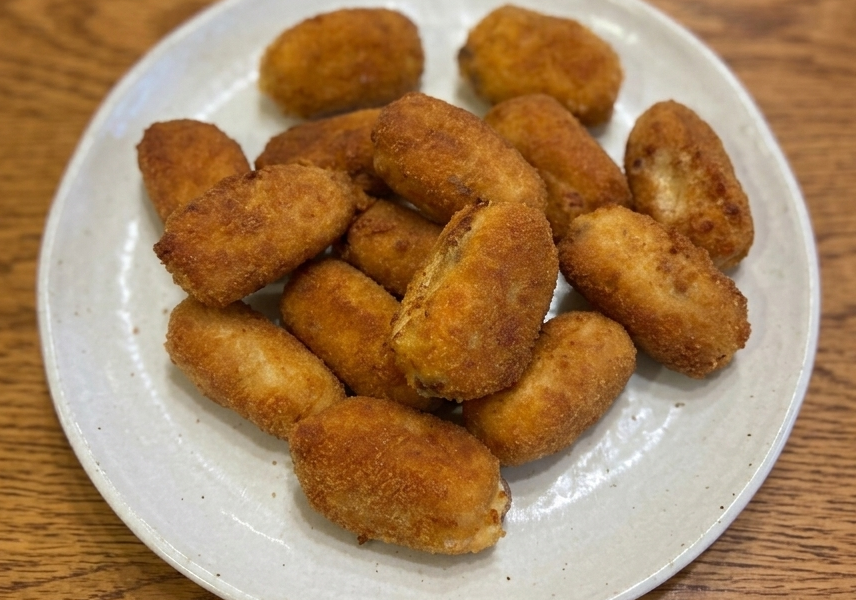 Plate of golden-fried croquetas de cocido madrileño, Spanish béchamel croquettes made from leftover stew meats